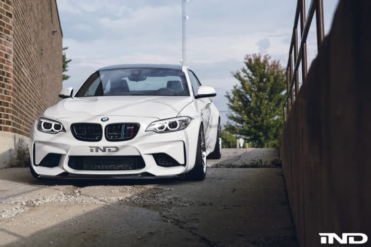 A slammed Alpine White BMW M2 With Carbon Fiber Goodies By IND Distribution