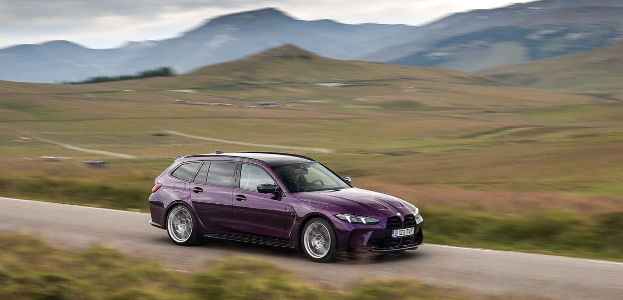 BMW M3 Touring Competition in Twilight Purple driving through Romanian mountain roads