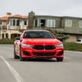 2026 BMW M850I HERITATE EDITION BRIGHT RED driving in Pebble Beach