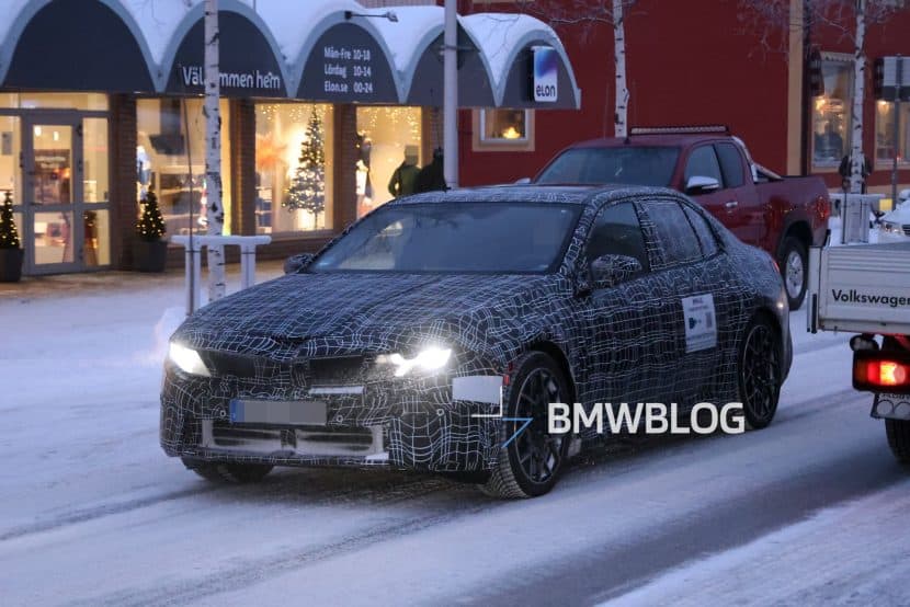 Prototype of the 2026 BMW i3 Sedan testing in winter conditions near Arjeplog with production headlights visible.