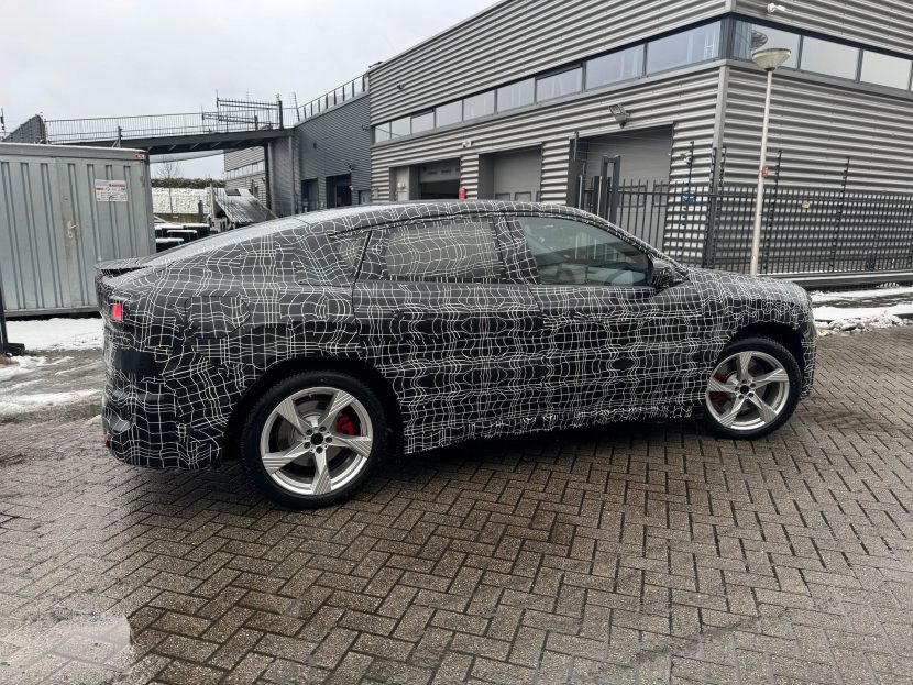 2027 BMW IX4 PROTOTYPE 01 BMW iX4 prototype with camouflage reveals sloping roofline and rakish coupe proportions